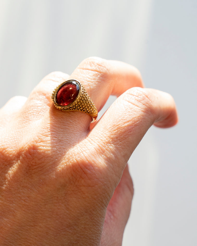 Antique garnet ring worn on a hand for scale. 