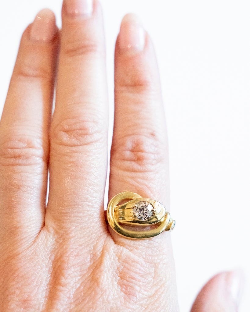 Victorian era diamond snake ring in 18k gold. An approximately 0.80 carat antique old European cut diamond in the head. English in origin. Circa 1890. Worn on a hand for scale. 