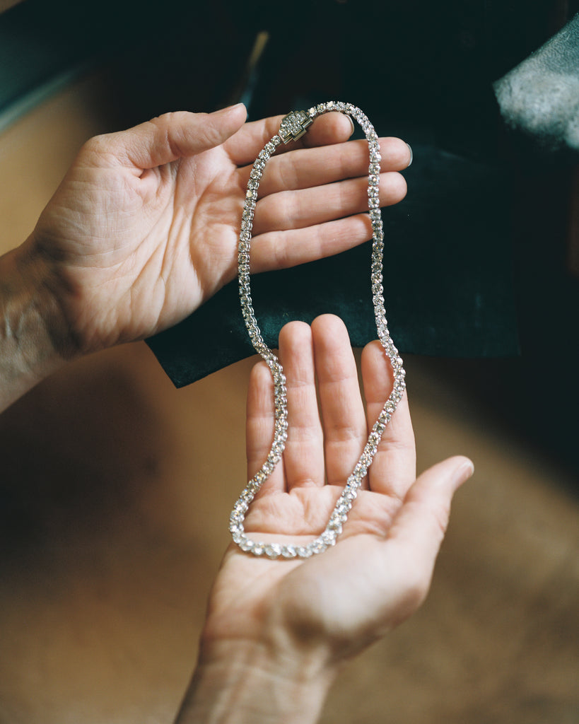 Photo of a jeweler holding a diamond necklace