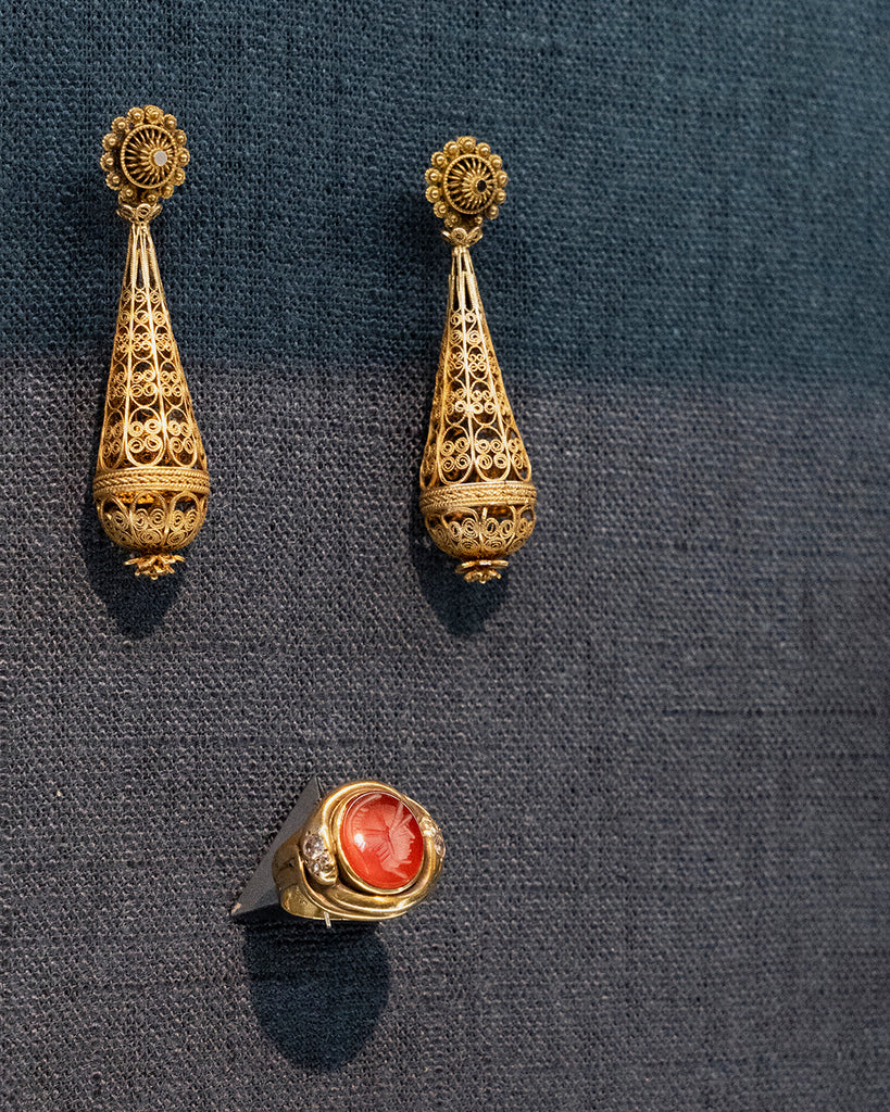 Early 19th Century gold torpedo shaped earrings. Creating cannetille work is a time-intensive process that involves stretching gold into thin threads and coiling the threads into elaborate and intricate designs. English in origin. Circa 1820. Next to a ring for scale. 